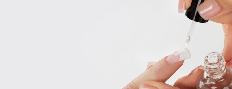 Person applying top coat on a light background